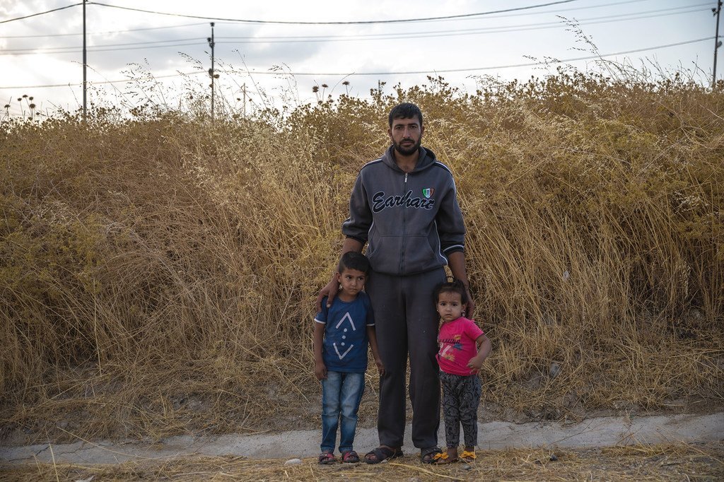 Un père syrien avec ses enfants au camp de Bardarash à Duhok, en Iraq, un jour après son arrivée.