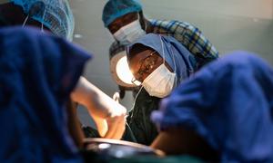 一位肿瘤学家在尼日利亚明纳的一家医院为一名患者进行手术。