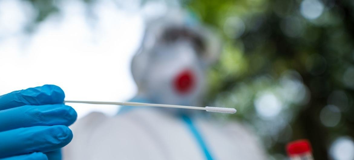 A lab technician collects a sample of a patient for covid testing in New Delhi, India.