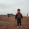 A young boy stands in a camp for people who have fled fighting in northwestern Syria.