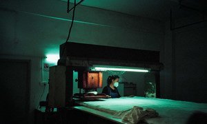 عاملة تشتغل على قطعة من القماش، في مصنع لٌعب في مدينة شنتشن ، الصين.