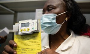Un responsable de la logistique à Kinshasa en République démocratique du Congo montre un capteur de température utilisé pour s'assurer que les vaccins contre la Covid-19 sont stockés à la bonne température.