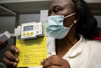 Un responsable de la logistique à Kinshasa en République démocratique du Congo montre un capteur de température utilisé pour s'assurer que les vaccins contre la Covid-19 sont stockés à la bonne température.