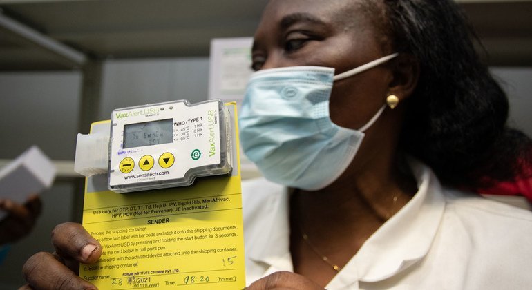 موظفة لوجستيات في كنشاسا في جمهورية الكونغو الديمقراطية تحمل مجسا لقياس الحرارة لضمان تخزين اللقاح بدرجة حرارة مناسبة.