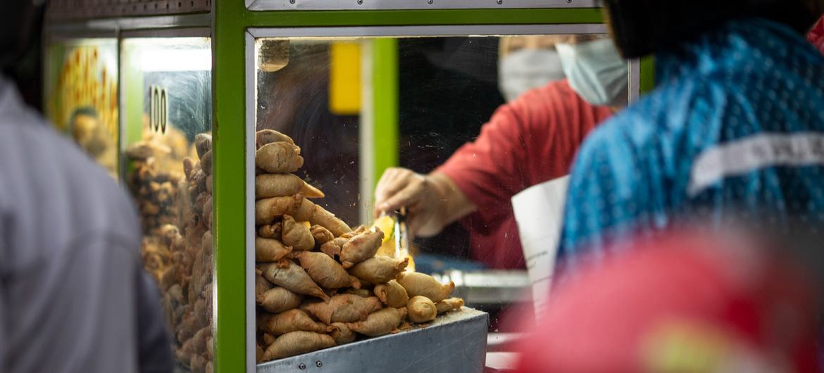 A street vendor sells fried food from his stall in Jakarta, Indonesia.
