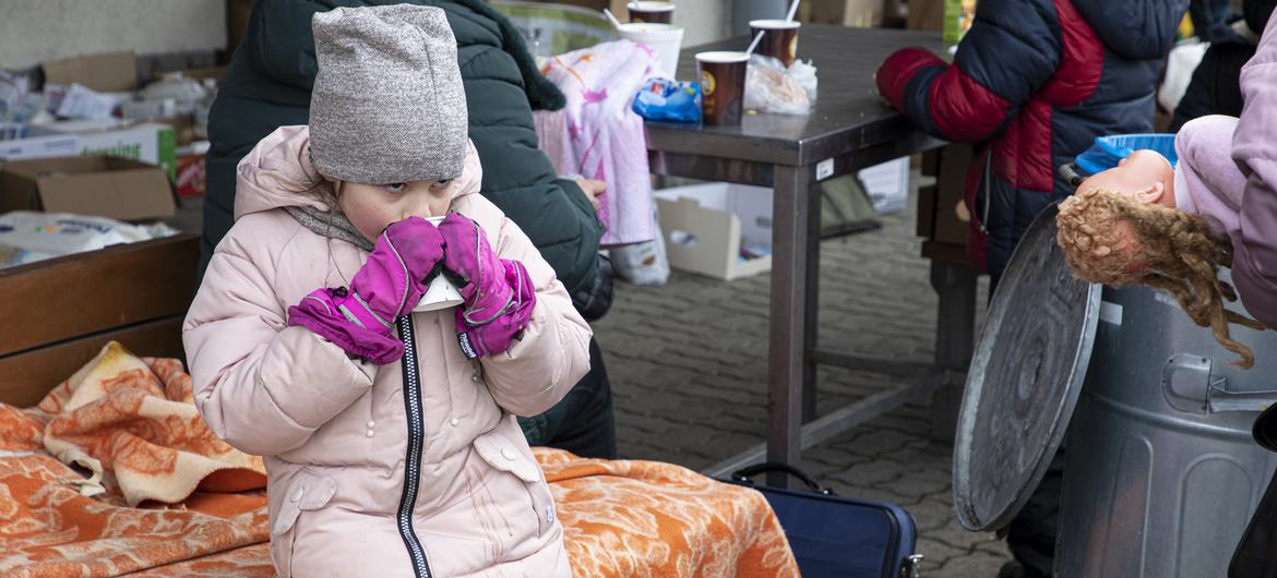 Una niña  toma una bebida caliente en la frontera entre Polonia y Ucrania