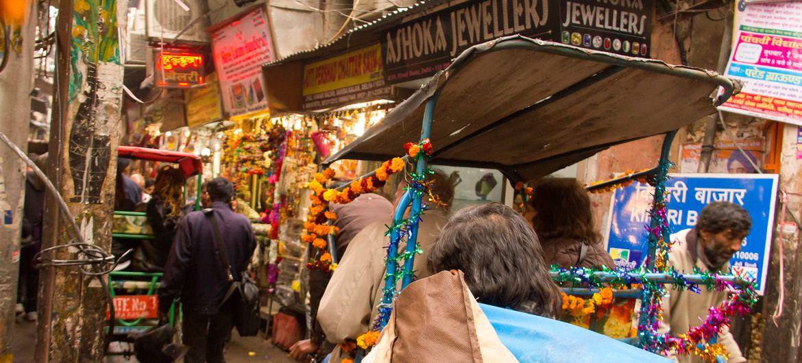 Via rickshaw, tourists explore the historical Chandni Chowk market in Delhi, India.