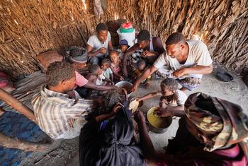 यमन में विश्व खाद्य कार्यक्रम से सहायता प्राप्त एक परिवार भोजन करते हुए.