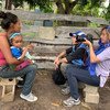 OCHA's Gema Cortés (right) interviews and photographs a woman in Bolivar, Venezuela prior to the outbreak of COVID-19.
