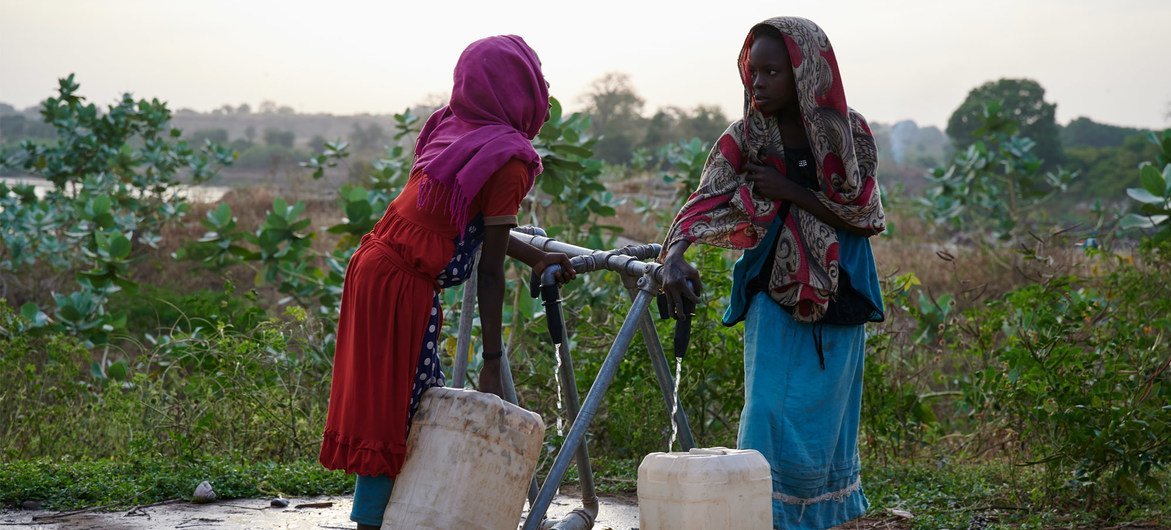 苏丹青尼罗州，两名女童在儿基会支持的设施前汲取清洁饮用水。