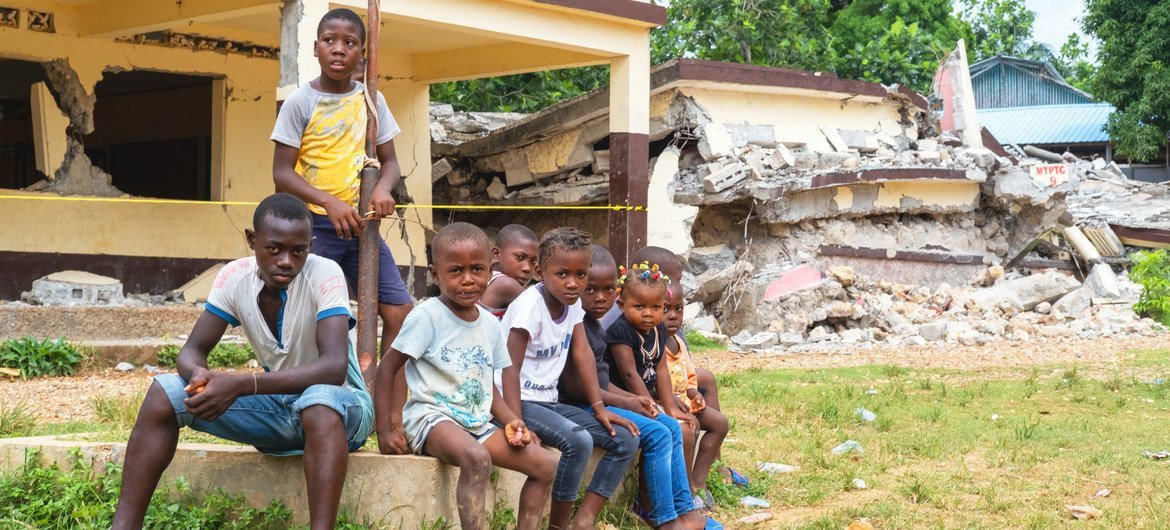 Children sit in front of their school, Notre Dame du Perpétuel Secours de Latibolière, destroyed during the 14th August earthquake in Haiti.