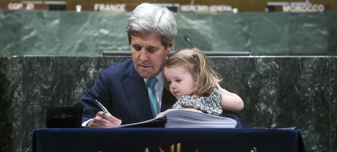 L'ancien chef de la diplomatie américaine, John Kerry, accompagné par sa petite-fille, signe l'Accord de Paris au siège de l'ONU en avril 2016.