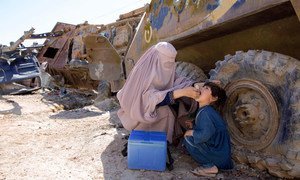 A UN-supported polio worker in Afghanistan administers a polio vaccine to a young child (file).  