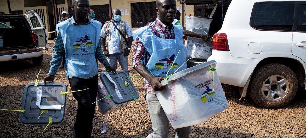 Poll workers carry ballot boxes during the 27 December 2020 presidential elections in the Central African Republic.