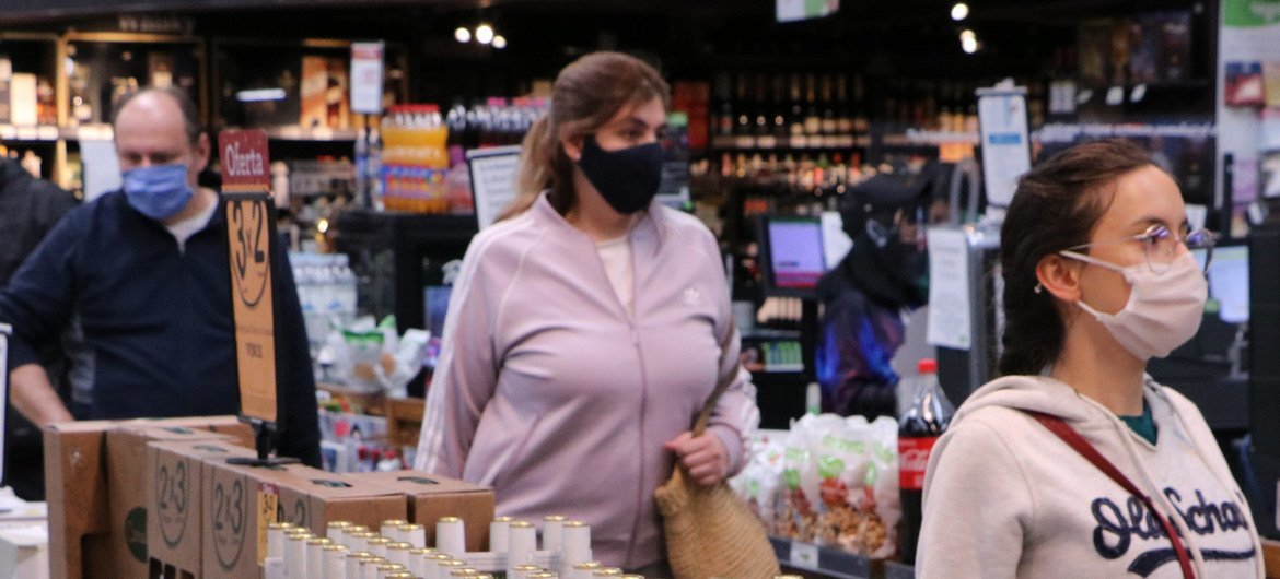 哥伦比亚首都波哥大的一家超市，排队等候结账的顾客佩戴口罩、保持社交距离。