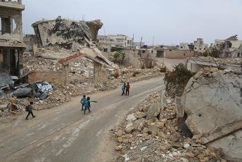 Children walk past ruins on their way home from school in Syria.