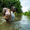 दक्षिण सूडान में जूबा के निकट नील नदी में बाढ़ में, एक लड़की स्कूल से घर वापसी के रास्ते पर नदी पार करते हुए.