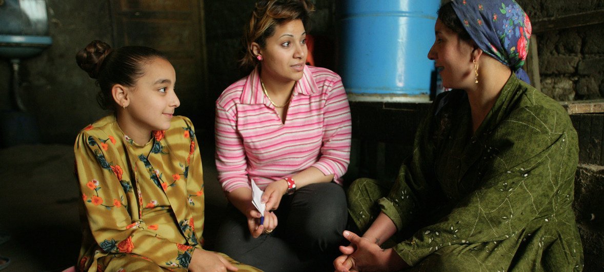 عاملة اجتماعية (في الوسط) تتحدث عن مخاطر تشويه الأعضاء التناسلية الأنثوية لفتاة ووالدتها في مصر.
