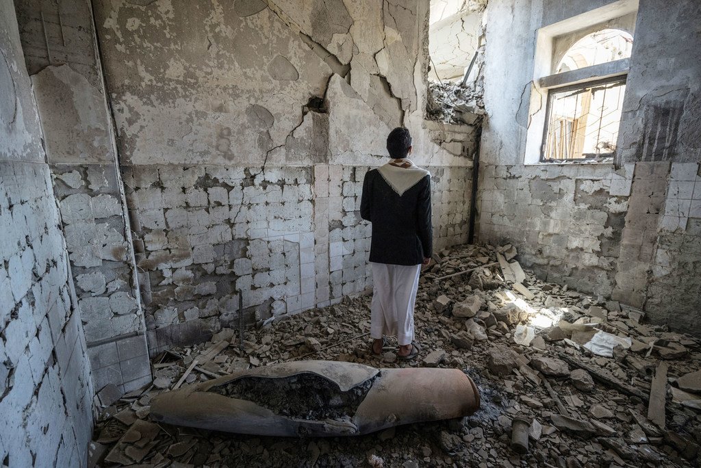 Un hombre se encuentra junto a la carcasa de un misil en un antiguo edificio del gobierno en la ciudad de Saada, Yemen.