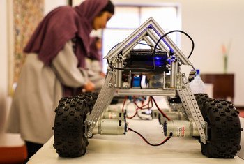 شابة أفغانية تشارك في معرض في العاصمة كابول، وبجوارها روبوت قامت بصنعه.