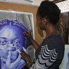 Msanii wa Kitanzania Annah anafanya kazi kwenye uchoraji mkubwa wa picha katika studio yake.