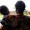 Mulher segura o filho em centro de apoio em Juba, no Sudão do Sul, depois de ser agredida pelo marido