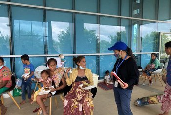 Funcionária da OIM, uma das agências da ONU que participa do apelo, fala com pessoas afetadas pelas enchentes em Timor-Leste