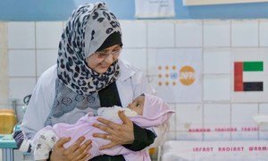 Une sage-femme tient un nouveau-né dans ces bras dans un hôpital soutenu par l'UNFPA à Abyan, dans le sud du Yémen.
