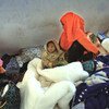 Une femme somalienne est assise avec son enfant d'un an, dans le centre de détention de Ganfoda, près de Benghazi, après avoir fui les violences dans son pays et pénétré illégalement en Libye.