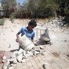 फ़लस्तीन के ग़ाज़ा सिटी के पास मलबा इकट्टा करता एक 13 वर्षीय बच्चा. ये मलबा वो खच्चर पर लादकर बेचने के लिए बाज़ार ले जाता है.