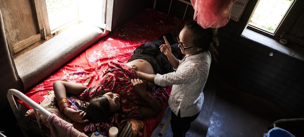A midwife administers an antenatal check up for an expecting mother at a healthpost in rural Nepal.