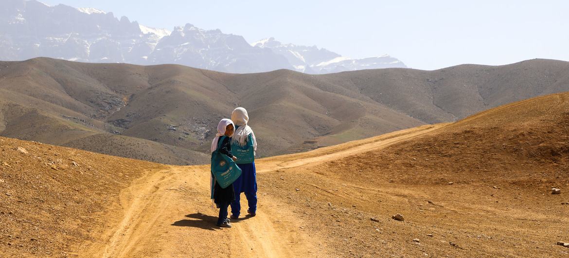 Students of the Warkak's accelerated learning center in Daikundi Province, Afghanistan, walk home together over the dusty hills.
