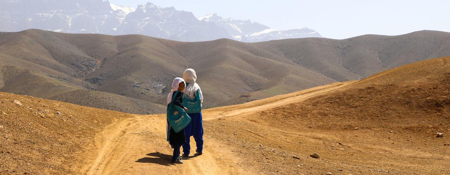 Des élèves du centre d'apprentissage accéléré de Warkak, dans la province de Daikundi, en Afghanistan, rentrent ensemble chez eux en marchant sur des collines poussiéreuses.