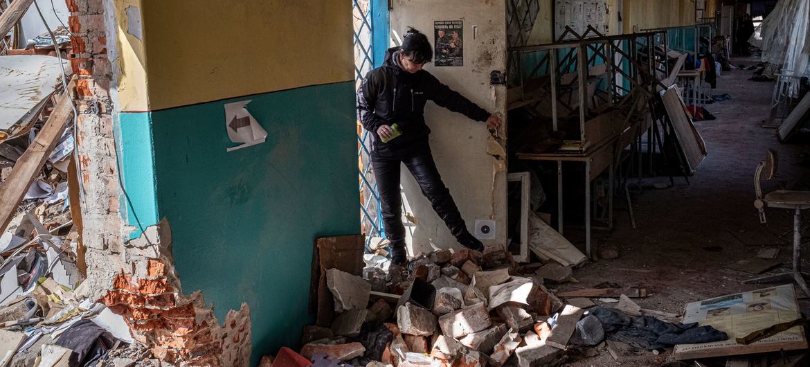 यूक्रेन के चेरनिहीफ़ में एक स्कूल के प्राध्यापक, हवाई बमबारी में स्कूल को पहुँची क्षति का निरीक्षण कर रहे हैं.