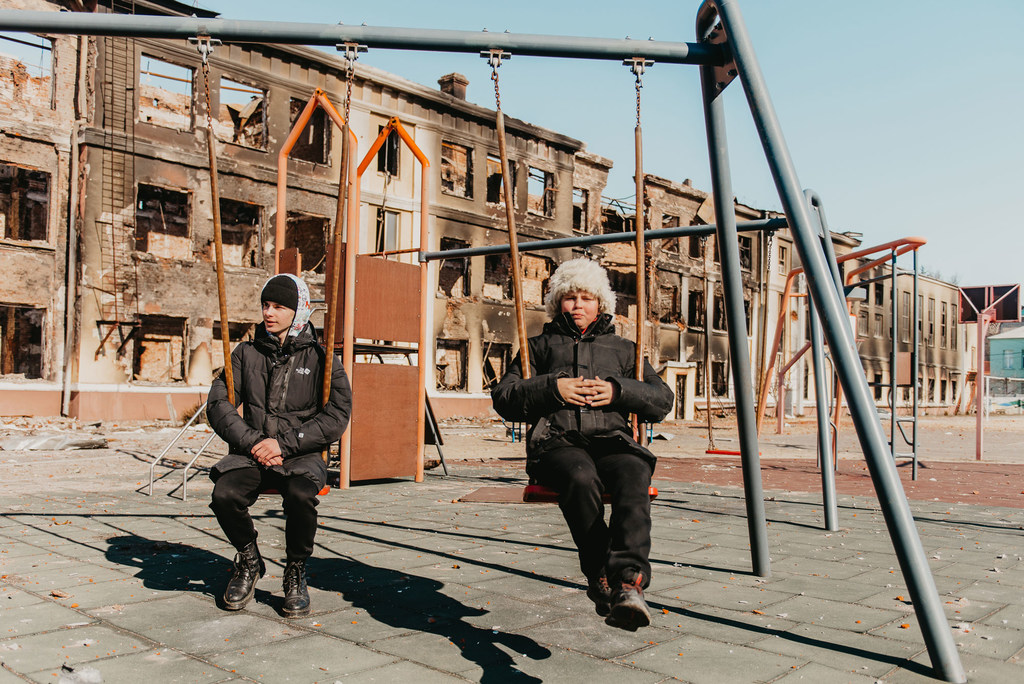 Two 14-year-olds play on the swings at their former school in Kharkiv, northeast Ukraine, after it was destroyed by shelling.