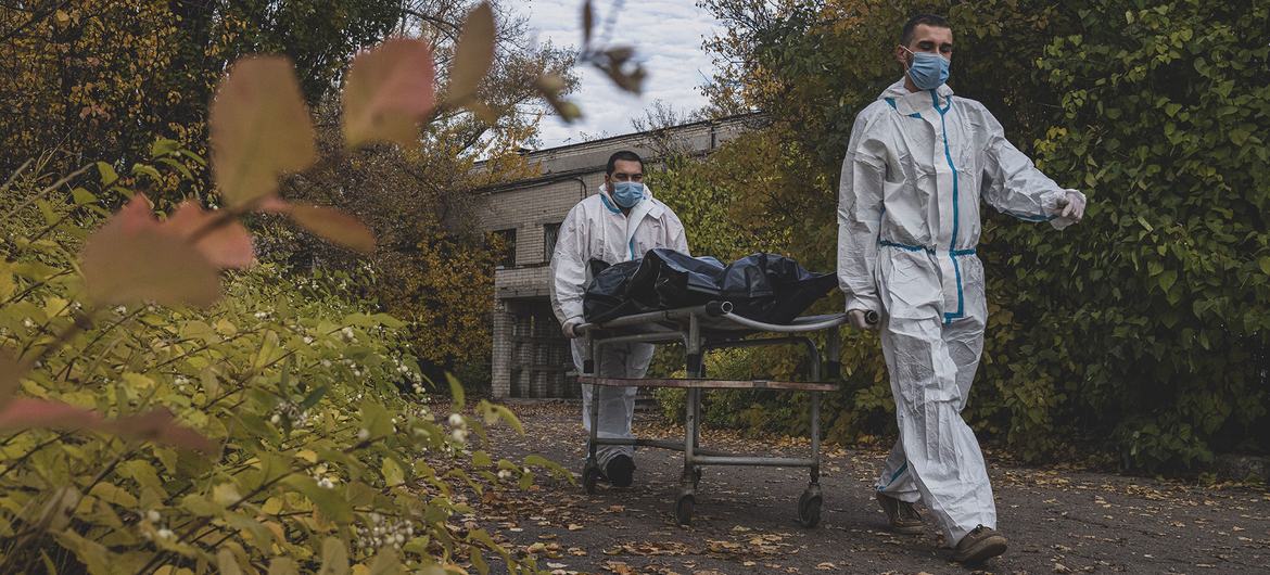 Enfermeros transportando el cuerpo de una persona víctima del COVID-19 a la morgue de un hospital en Kharkiv, Ucrania.