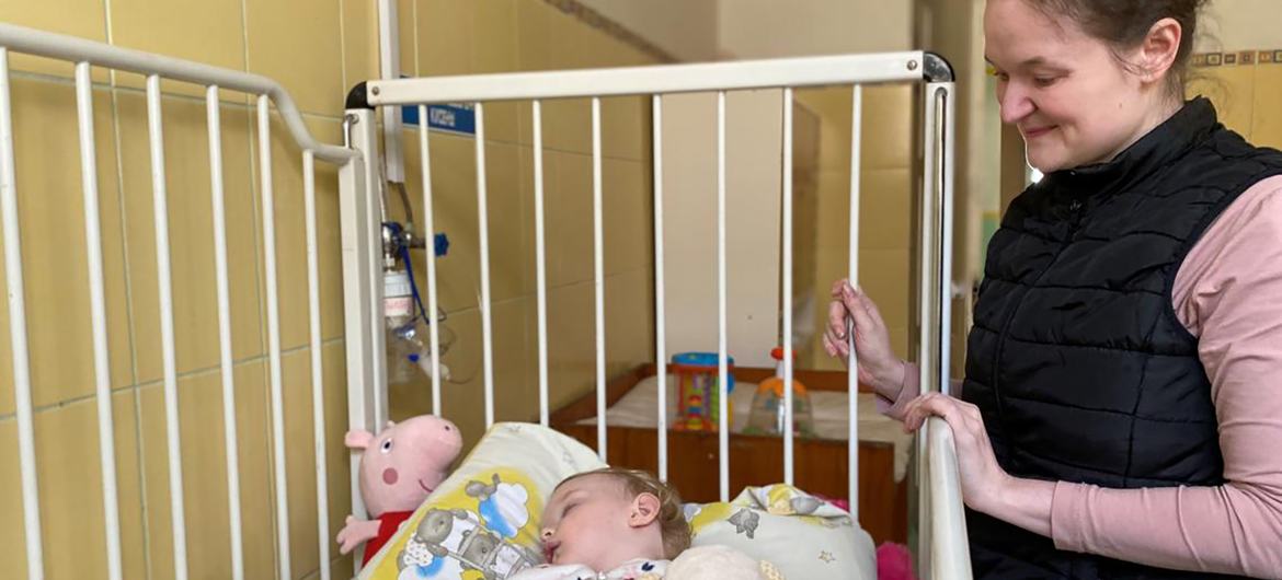 زينة تقف بجانب سرير أليس في مستشفى للأطفال في لفيف، غرب أوكرانيا.