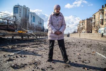 A woman stands in debris caused by shelling in Beresteisk in Kyiv, Ukraine.