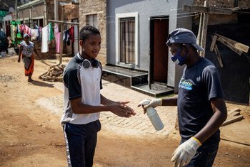Le 23 avril 2020 à Johannesburg, en Afrique du Sud, un habitant du quartier informel de Setswetla se fait asperger les mains de désinfectant pour les mains. 