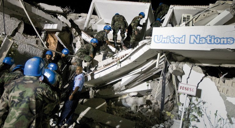 在2010年1月海地大地震发生后，联合国维持和平人员在特派团总部的废墟中寻找生还的同事。