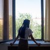 Une jeune fille de 14 ans regarde par la fenêtre, à Kyzylorda, au Kazakhstan. Récemment, elle a abordé les sentiments de stress et d'anxiété avec l'aide d'un psychologue scolaire. 