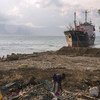 Una mujer busca entre los escombros de una playa en Palu, Indonesia, que fue arrasada por un tsunami en 2018.