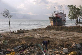 Una mujer busca entre los escombros de una playa en Palu, Indonesia, que fue arrasada por un tsunami en 2018.