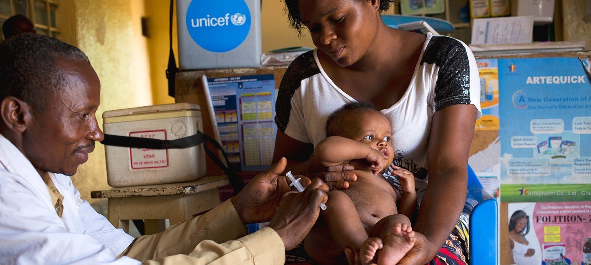 在刚果民主共和国卢本巴希的一家卫生中心里，一名母亲抱着她3个月大的婴儿接受麻疹疫苗接种。