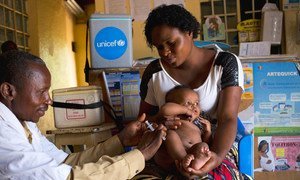 A mother holds her 3-month-old baby as he receives a vaccination against measles at a health centre in Lubumbashi, Democratic Republic of the Congo.