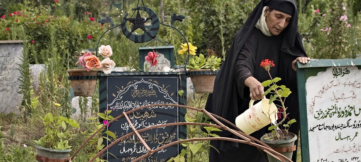A mother waters the plants adorning her son's grave in the disputed Kashmir region (file photo)..