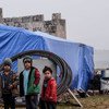 Children pose outside a tent in a camp for displaced people in Idlib, northern Syria. 