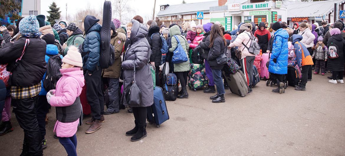 यूक्रेन के पश्चिमी इलाक़े में, 5 मार्च को बच्चे व परिवार, पोलैण्ड की तरफ़ जाने वाले रास्ते पर.
