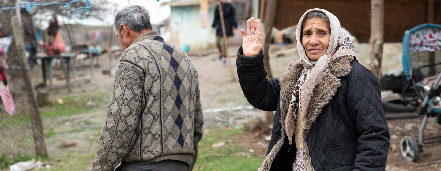 A Roma woman waves hello in Chirnogi, Romania