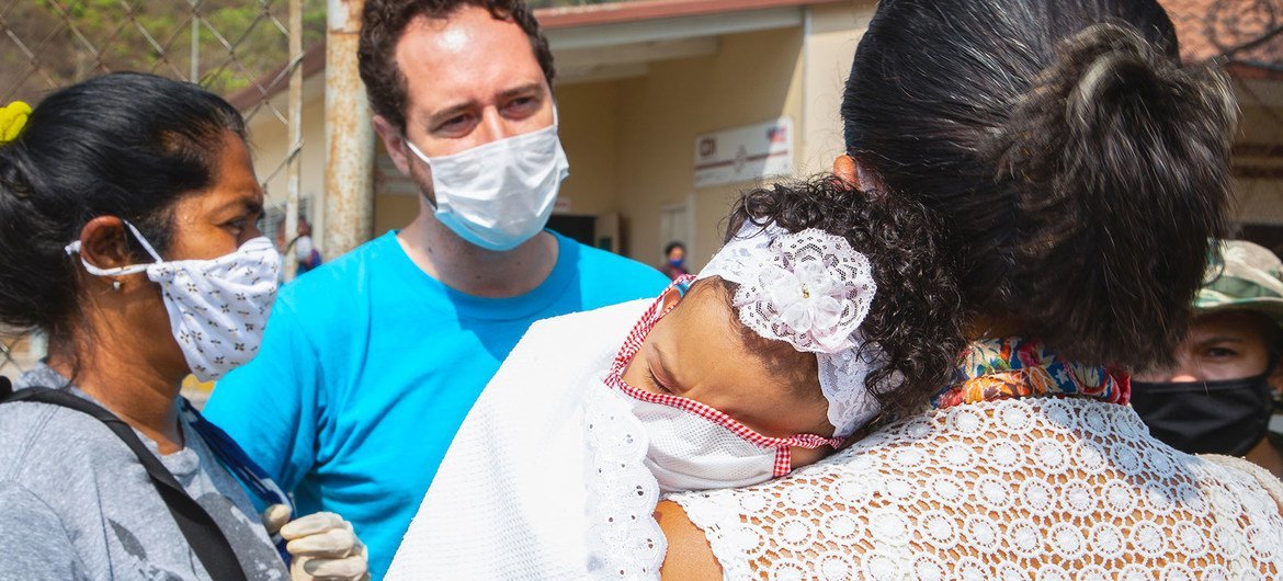 Un trabajador de UNICEF habla con nas mujeres en un centro de salud de las afueras de Caracas,Venezuela